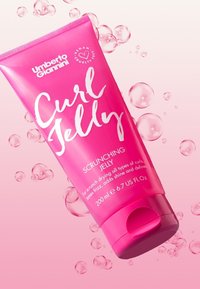 Tube rose de Gel Curl avec une finition mate, présentant un texte blanc et un capuchon à rabat. Contient 200 ml ; accentué par des bulles flottantes.