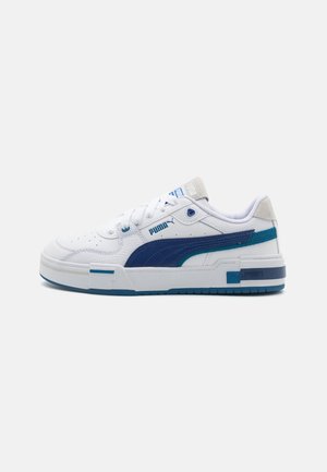 Zapatillas Puma con un upper de cuero blanco, acentos azules, suela intermedia gruesa y detalles texturizados; cuenta con cierre de cordones y logotipo.