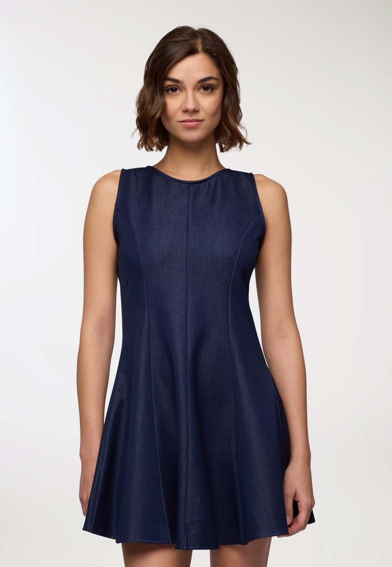 Abito senza maniche blu navy con gonna svasata e texture liscia; presenta un collo rotondo e dettagli delle cuciture sul corpetto.