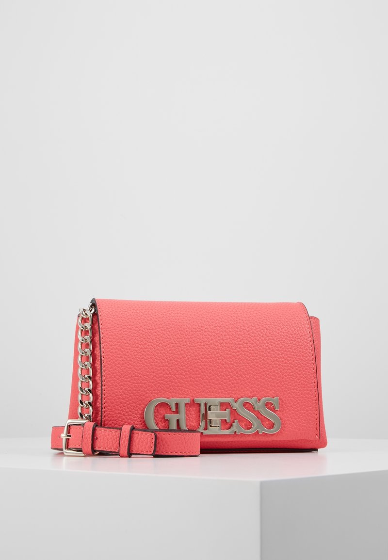 Borsa a tracolla rosa corallo con superficie testurizzata, logo in metallo argentato "GUESS", tracolla removibile e dettaglio a catena sulla tracolla.
