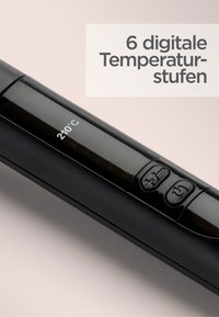 Hair styling tool with a black body, digital display showing 210°C, and three control buttons for temperature adjustment.