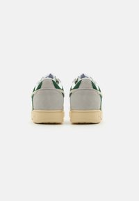 Grey and green sneakers with suede and mesh materials, feature a low-profile design and beige rubber soles visible from the back view.