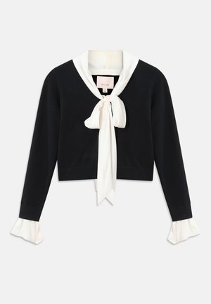 Schwarzer, langärmeliger, kürzer geschnittener Pullover mit angehängtem weißen Kragen, vornem Schleifenbinder und weißen Rüschenbündchen an den Ärmeln.