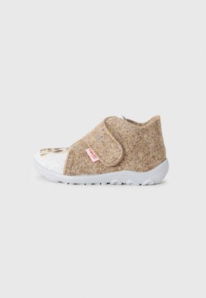 Brown felt children's slipper with a white toe cap, Velcro strap, and rubber sole featuring a textured pattern. Bright red branding tag visible.