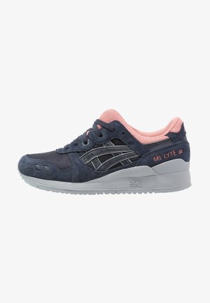 Sneaker ASICS Gel Lyte III blu navy e rosa con parte superiore in suede e mesh, suola grigia e dettagli brandizzati sul tallone e sul lato.