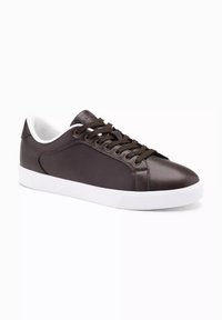 Sneakers in pelle marrone con una texture liscia, suola in gomma bianca e lacci marroni. Dettaglio della cucitura laterale e interno ammortizzato.