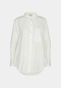 Camicia bianca a maniche lunghe in cotone, con chiusura a bottoni sul davanti, colletto a punta e una tasca sul petto. Tessuto semplice; orlo arrotondato.