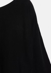 Črn pleten pulover s sproščenim in ohlapnim krojem ter širokim čolnastim izrezom. Mehak material z minimalnimi detajli.