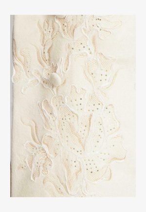 Cremefarbener Wollstoff mit aufwendiger floraler Stickerei in sanften Beige- und Weißtönen, akzentuiert durch kleine goldene Pailletten. Strukturierte Oberflächendetails.