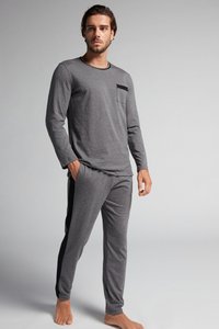 Grijze heren pyjama met lange mouwen en een zwart zakdetail. Zachte stof, relaxed fit, met bijpassende grijze broeken met zijstripes.