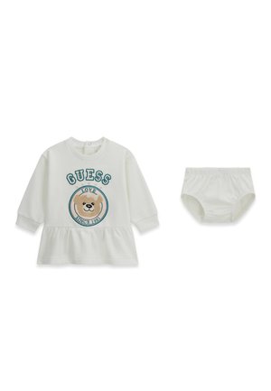 Robe bébé blanche à manches longues avec "GUESS" et imprimé ourson, associée à une culotte de protection blanche assortie.