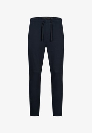 Mörkblå joggingbyxor i mjukt tyg, med elastisk midja och dragsko samt avsmalnande ben. Inga synliga mönster eller detaljer.