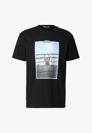 Černé tričko s grafikou osoby za plotem držící se mříží, nad obrázkem je nápis "NESPRAVEDLIVÉ".