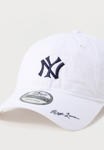 Λευκό ρυθμιζόμενο καπέλο μπέιζμπολ με σκουρομπλε κεντημένο λογότυπο "NY" στο μπροστινό μέρος και διακριτικό στοιχείο υπογραφής στην τσέπη.