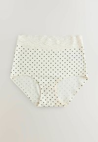 Culotte blanche taille haute pour femme avec des pois noirs et une large ceinture en dentelle blanche, posée à plat sur une surface claire.
