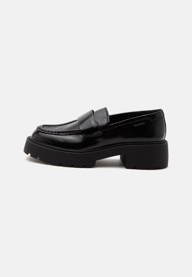 Μαύρο γυαλιστερό δερμάτινο loafer με χοντρή σόλα και χαμηλό τετράγωνο τακούνι, ραφές στο πλάι και φαρδιά λωρίδα πάνω από το πάνω μέρος.