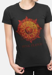 Černé bavlněné tričko s designem slunce v červené a oranžové barvě, které má obličej a je obklopeno paprsky, s textem "PINK FLOYD" níže v tučném červeném písmu.