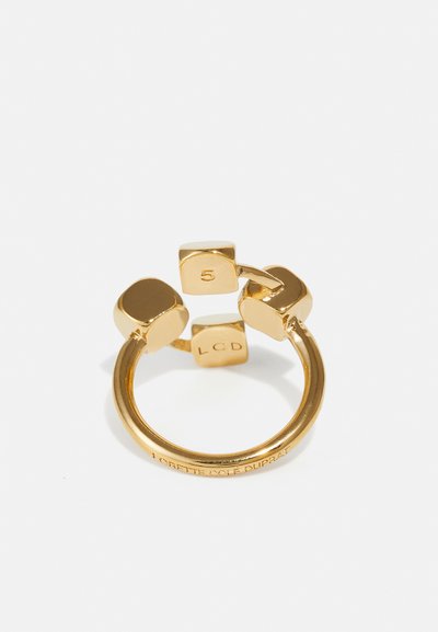 Bague en or ornée de trois accents carrés, dont un gravé avec le chiffre "5" et un autre avec "LCD", finition lisse avec un aspect poli.