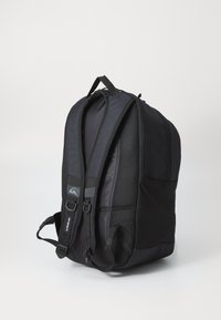 Schwarzer Rucksack mit gepolsterten Schultergurten, Mesh-Akzenten und einem Hauptfach. Verfügt über ein Logo-Patch und Seitentaschen für Zubehör.