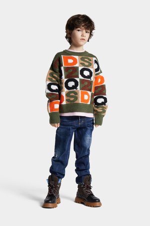 Knit sweater featuring a grid pattern in green, orange, beige, and black with block letters. Paired with dark blue jeans and black boots.