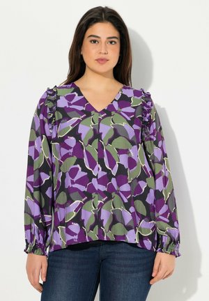 Blouse fleurie violette et verte avec un décolleté en V, des manches longues et des accents volants. Tissu texturé avec des poignets élastiques et une coupe décontractée.