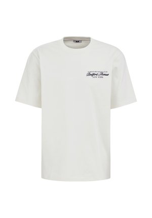 Maglietta bianca a maniche corte con scollo a girocollo e testo nero "Downtown Social Club Bedford Avenue New York" sul petto a sinistra.