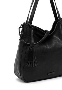 Sac à main en cuir noir texturé avec double bandoulière, pompon décoratif et étiquette métallique de la marque sur le devant.