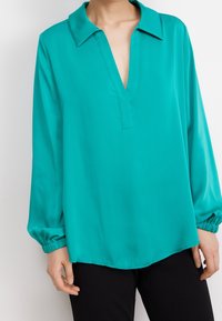 Turquoise blouse with a notched collar, long sleeves gathered at the wrists, and a smooth, lightweight fabric. Features a relaxed fit.