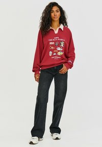 Bordové mikina s bílým límcem, grafický potisk, volný střih. Odpovídá s černými širokými kalhotami a bílými teniskami.