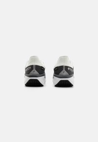 Sneaker mit einem Obermaterial aus weißem und schwarzem Mesh, GORE-TEX-Branding, gepolstertem Fersenbereich und einer strukturierten Gummi-Außensohle für Traktion.