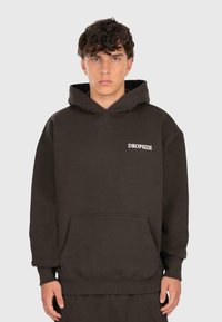 Sudadera con capucha marrón de algodón, con un bolsillo canguro frontal y el logo blanco "DROPSIZE" en el pecho. Textura suave.
