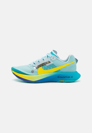 Chaussure de course Nike bleu clair avec swoosh jaune, semelle intermédiaire dégradée du bleu au jaune, et inscriptions "ZoomX" et "Vibram" sous la semelle.