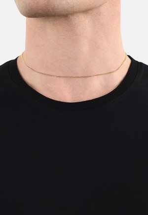Gouden metalen chokerketting met een dun, rond schakeldesign, rustend om de nek boven een zwart shirt, met een gladde textuur.
