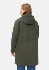 Olivengrøn hættejakke med lige snit, der har en indsnøret talje, knaplukning ved manchetterne og minimalistisk design. Glat tekstur, afslappet pasform.