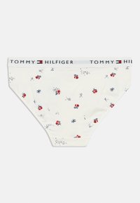 Λευκό βαμβακερό εσώρουχο με λουλουδάτο μοτίβο που περιλαμβάνει κόκκινα τριαντάφυλλα και μπλε λεπτομέρειες. Λάστιχο στη μέση με το λογότυπο "TOMMY HILFIGER" σε μαύρο και λευκό.