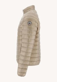 Giacca a vento beige con colletto alto e texture trapuntata orizzontale. Presenta una toppa con logo sulla spalla sinistra. Materiale leggero.