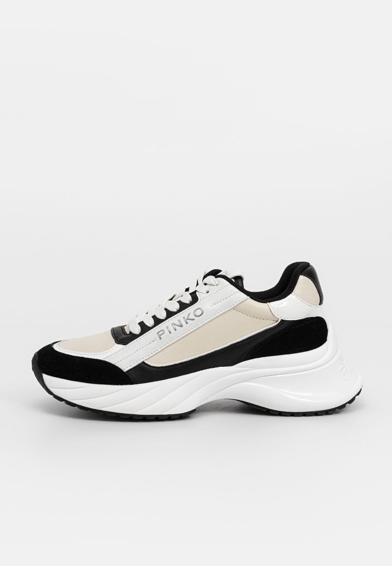 Baskets noires, blanches et crème avec un design épuré, réalisées en cuir suédé et en cuir, à bout arrondi, semelle épaisse et détail de logo sur le côté.