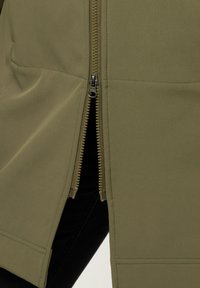 Veste vert olive présentant un zip remarquable sur le côté, fabriquée en tissu lisse avec un design structuré et des accents épurés.