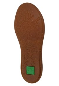 Suela de zapato de goma marrón con un patrón texturizado y un logo de rana verde. El diseño incluye varias formas y contornos para una mejor tracción.