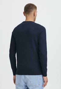 Navyblaues Pullover-Sweatshirt aus weichem Stoff, mit langen Ärmeln und Rundhalsausschnitt, mit gerippten Bündchen und Saum.