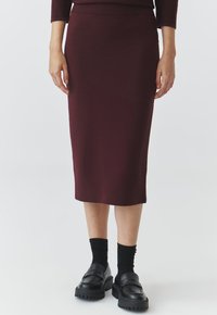 Gonna midi in magenta con vita aderente, abbinata a mocassini neri chunky e calzini. Tessuto morbido, dettagli a coste sulla vita.