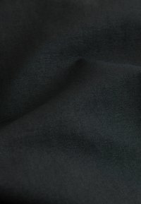 Material negru cu o suprafață netedă, texturată, având un model ușor țesut. Materialul pare a fi durabil și flexibil.