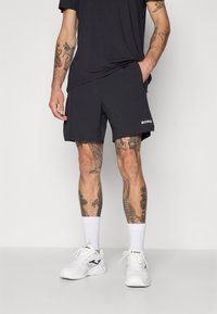 Svarte sportsshorts med lommer, over kneet lengde, teksturert stoff, med hvit "BORG" logo på siden.