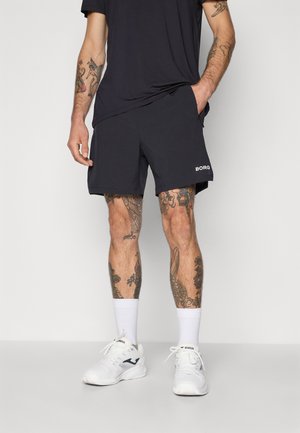 Bermuda de sport noire avec poches, longueur au-dessus du genou, tissu texturé, arborant un logo blanc "BORG" sur le côté.