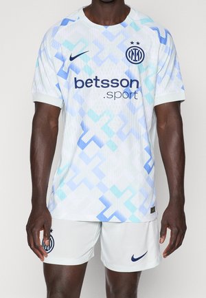 Man wearing a white and blue patterned football jersey and shorts with Inter Milan, Nike, and Betsson Sport logos.