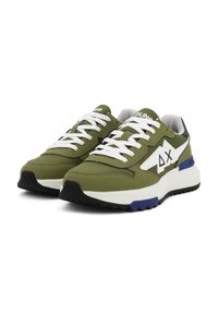 Zapatillas verde oliva con cordones blancos, que presentan un diseño triangular y acentos azules. La tela texturizada y la suela de goma ofrecen agarre.
