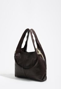 Brązowa skórzana torebka o miękkiej, gładkiej strukturze, z luźnym fasonem, miękkimi paskami na ramię i dekoracyjnymi akcentami metalowymi.