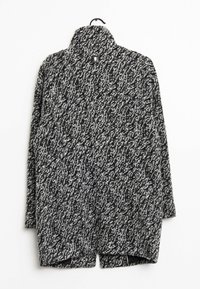 Gestructureerde cardigan in zwart en wit breiwerk met een hoge kraag, open voorkant en zijsplitten, voorzien van een klein label bij de nek.