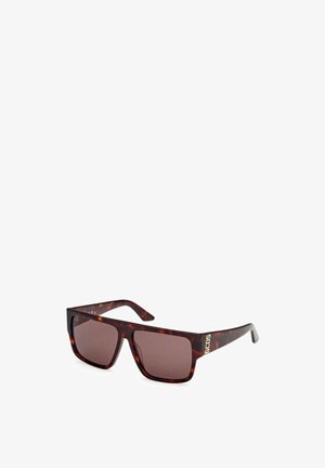 Gafas de sol marrón carey con lentes cuadrados, sutil degradado marrón y un acento de logo dorado en la patilla. Montura de plástico, diseño moderno.