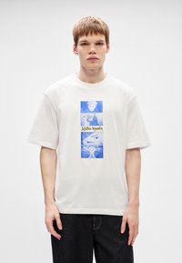 Λευκό βαμβακερό T-shirt με μπλε γραφικό σχέδιο χαρακτήρων και κείμενο "Jujutsu Kaisen" σε κεντρικό πάνελ. Χαλαρή σχεδίαση με κοντά μανίκια.